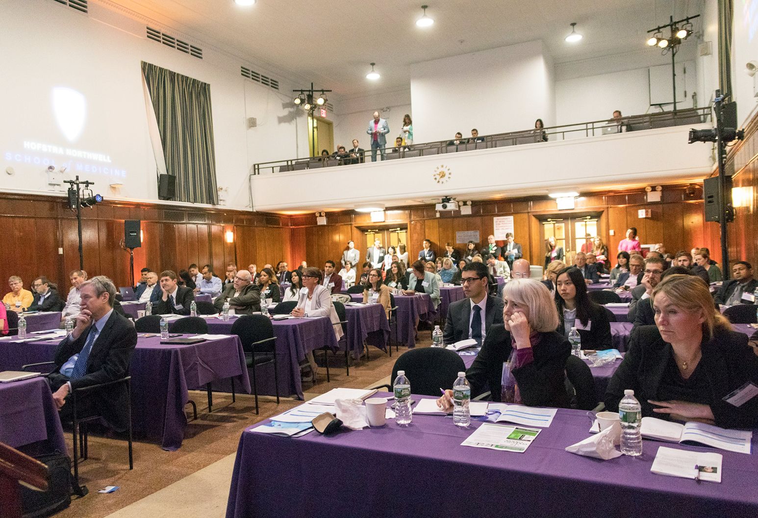 Large meeting room of attendees watching a presentation