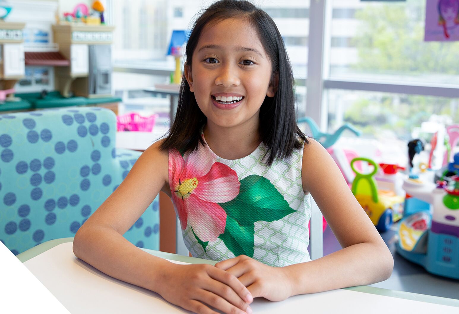 Young girl with dark hair wearing a colorful dress