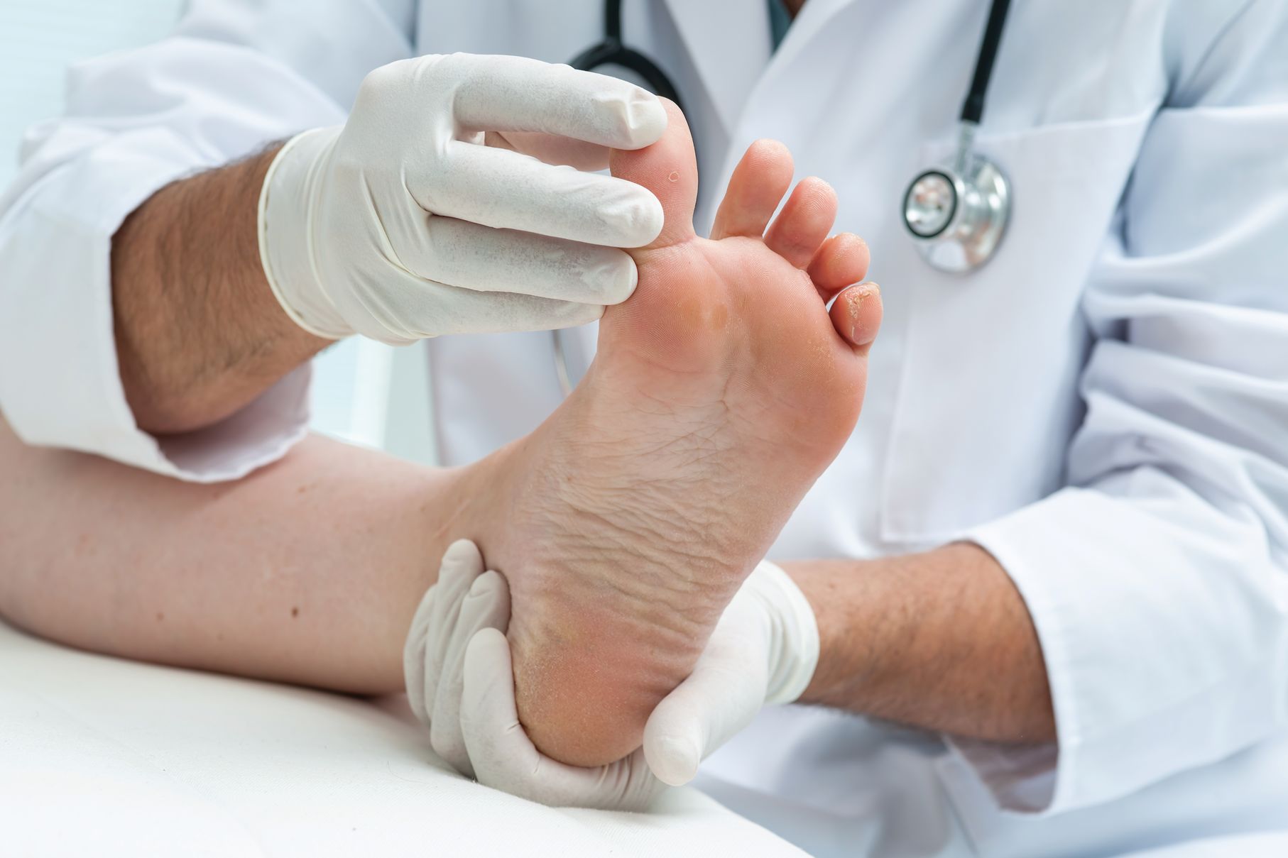 A podiatrist looks at a foot