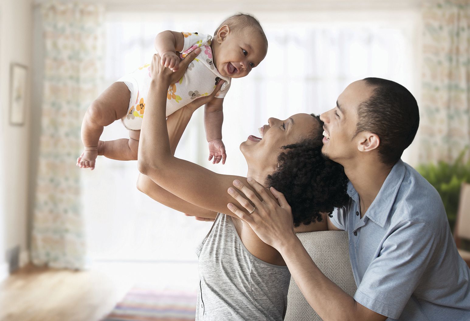 Parents gazing up at baby they are holding