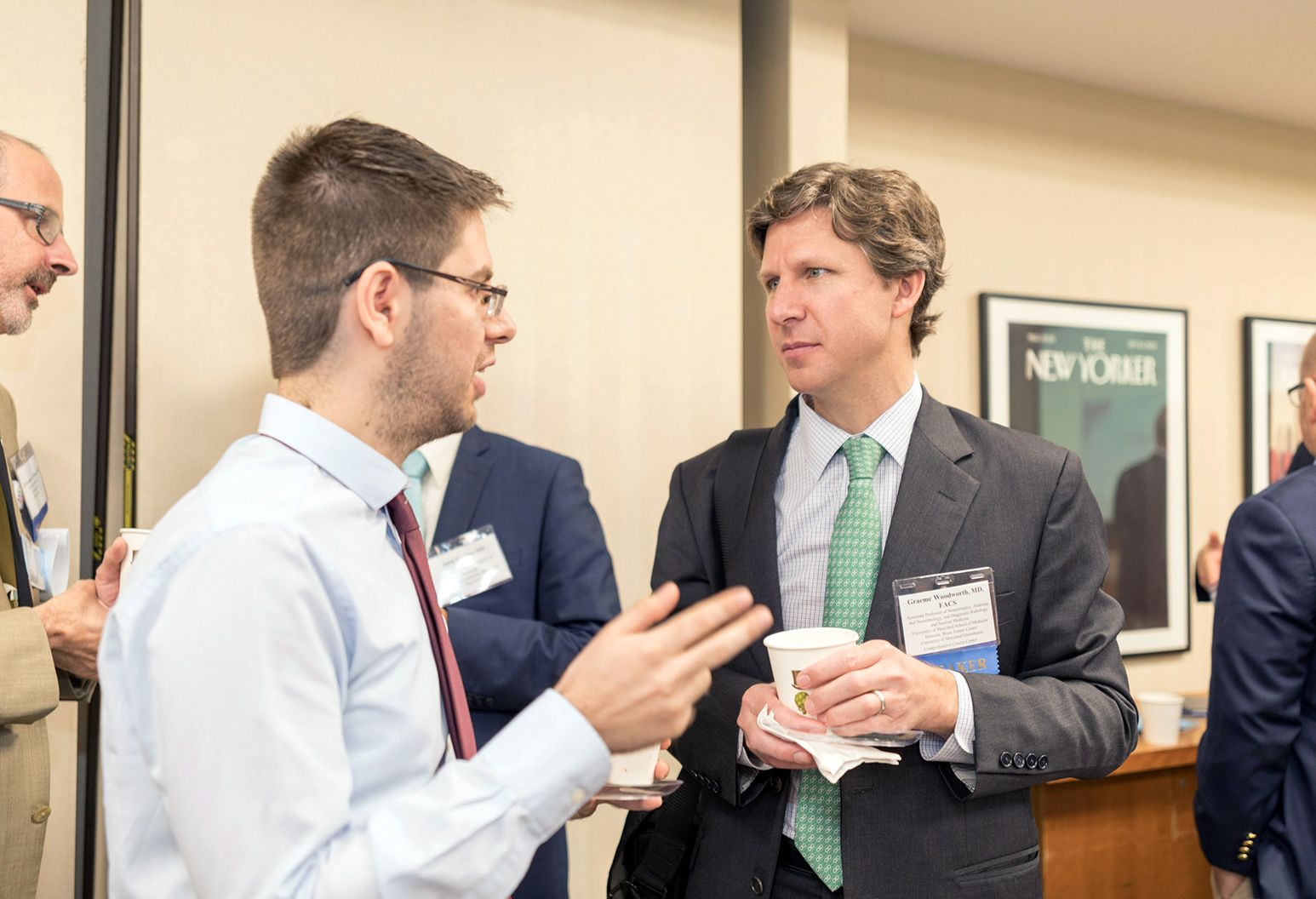 Two professionals are talking in the hallway at a conference