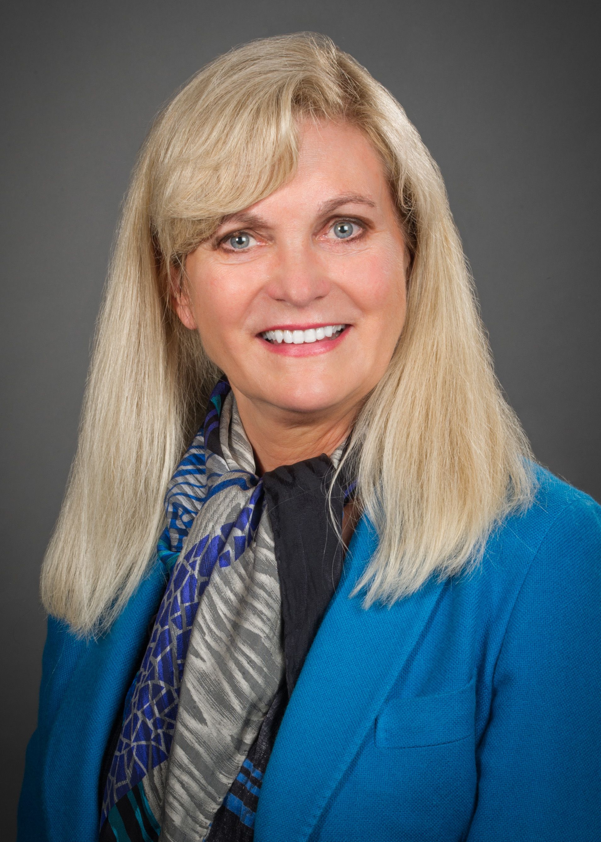 Cindy Grines, MD, wearing a blue jacket and multi-colored scarf
