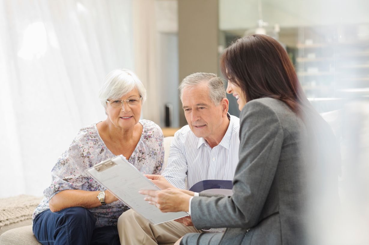 A female goes over a care plan with an elderly couple.
