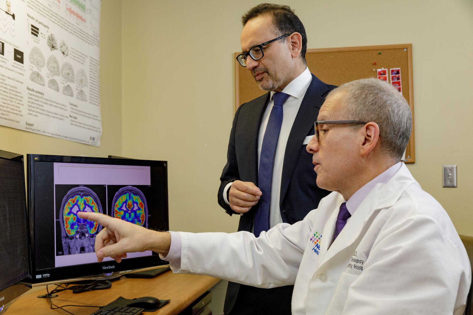 Ashesh Mehta, MD, PhD, works with another clinician while looking at a diagnostic image.