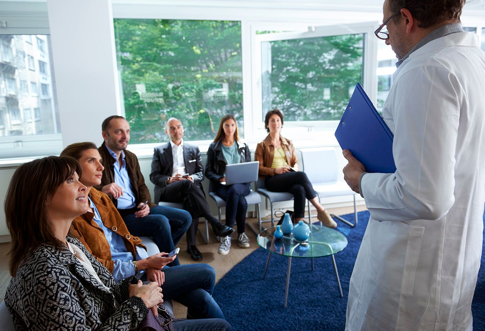 A physician lecturing a room full of adult students.