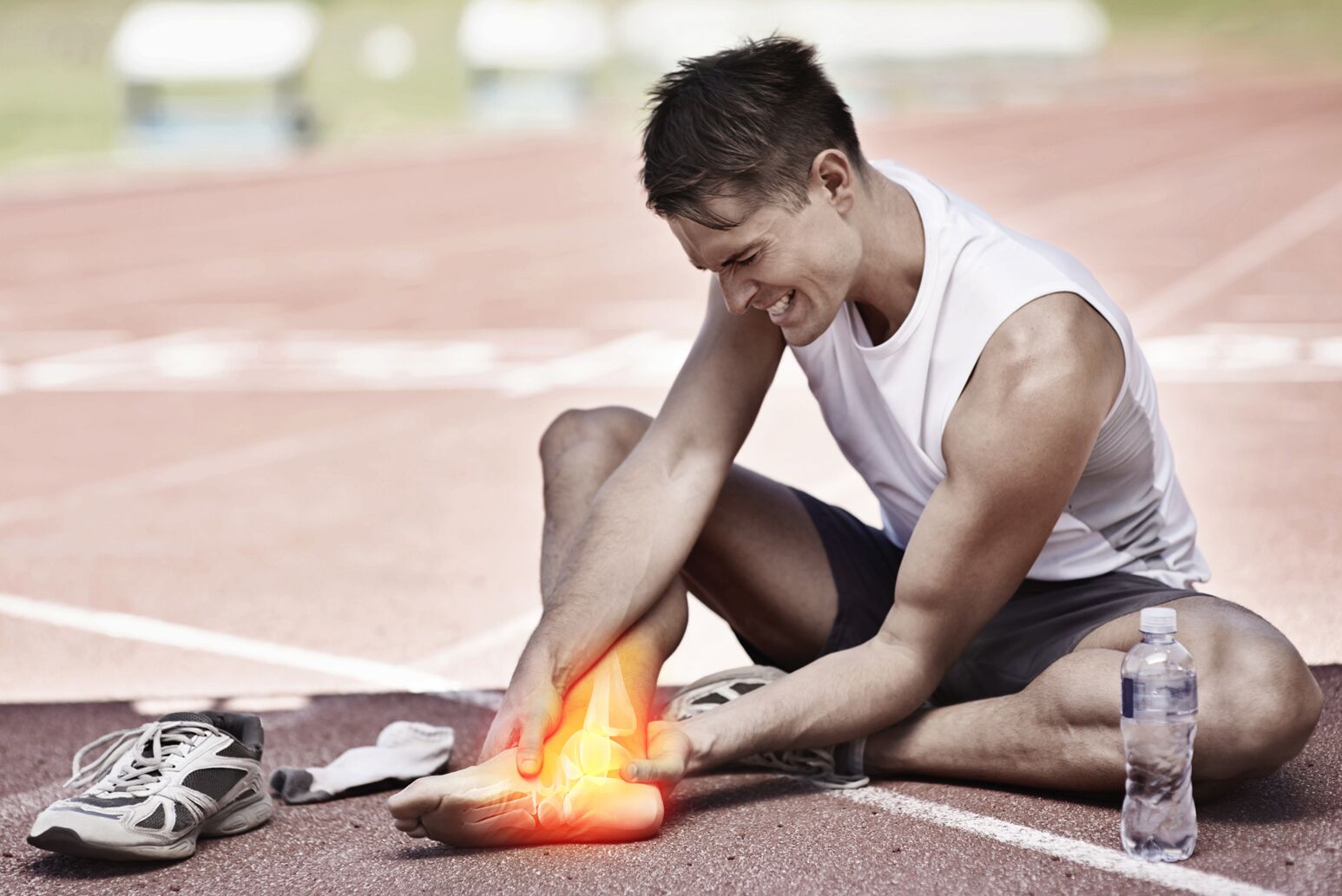 A runner holds his ankle after an injury.