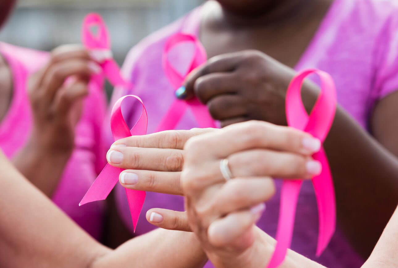 Women hold pink ribbons for breast cancer