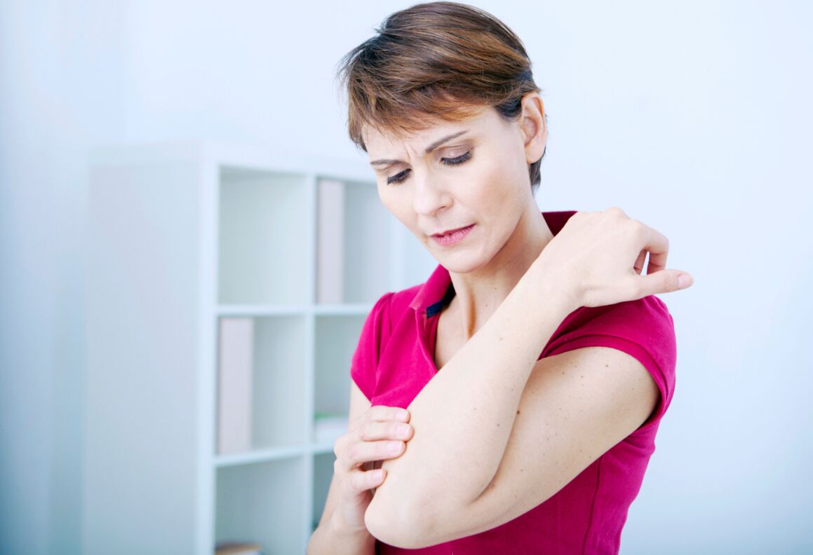 A woman holds her elbow