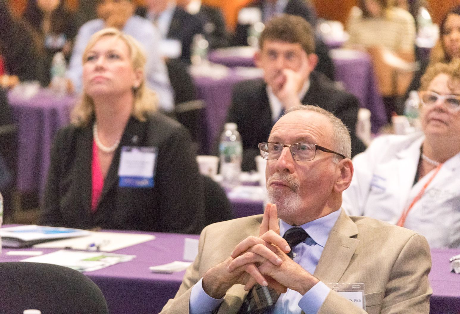 Group of professionals watch a presentation at a conference