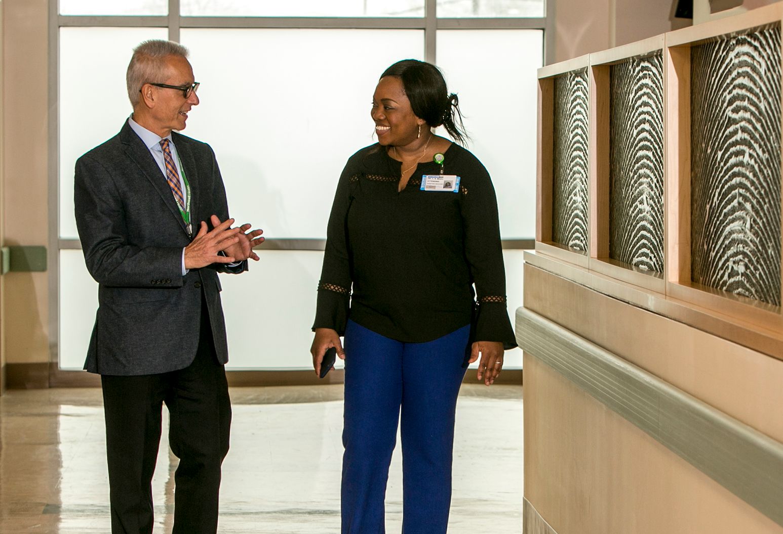 Two doctors walking and talking in hospital hallway