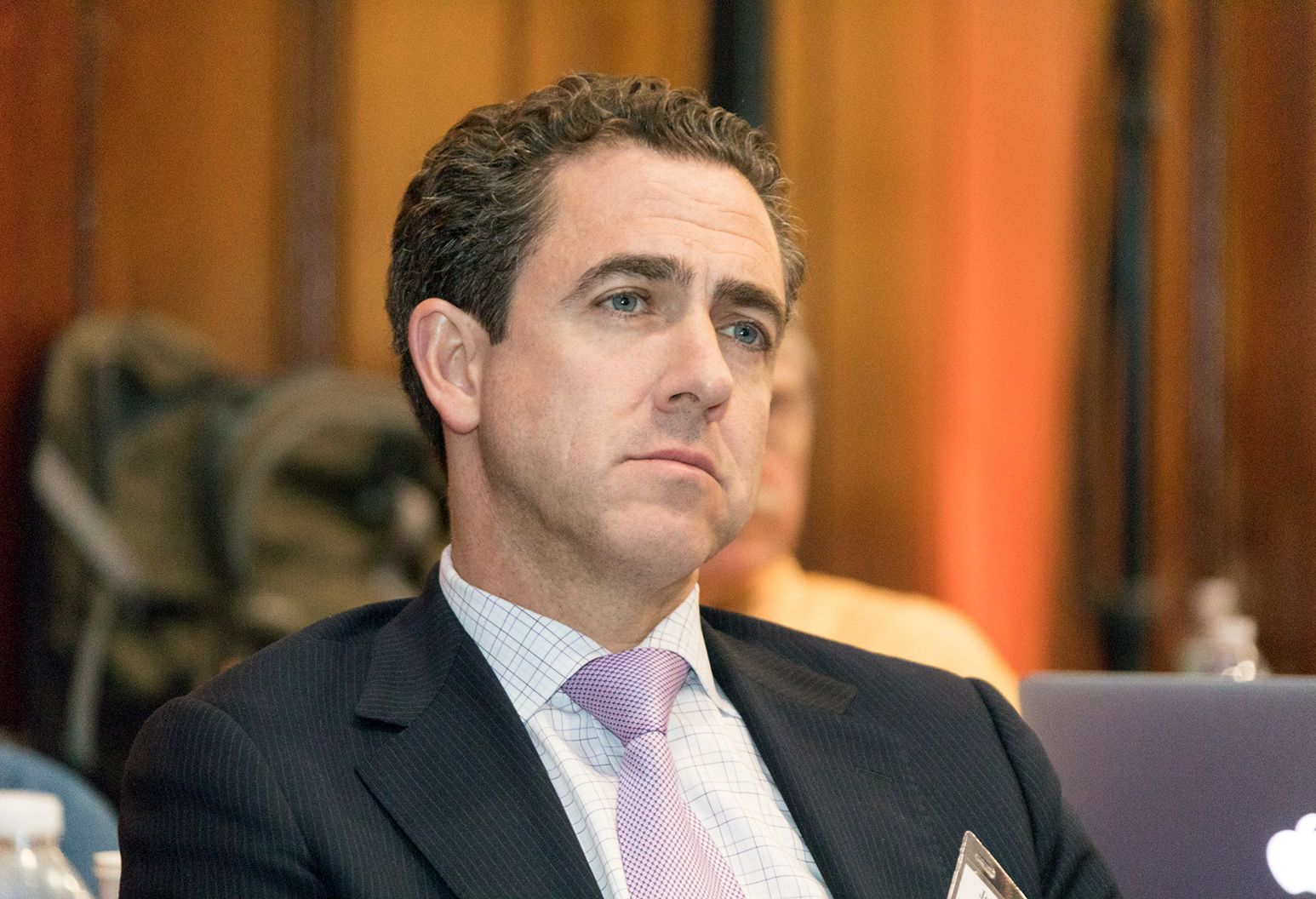 Close up photograph of a middle aged male doctor watching a presentation