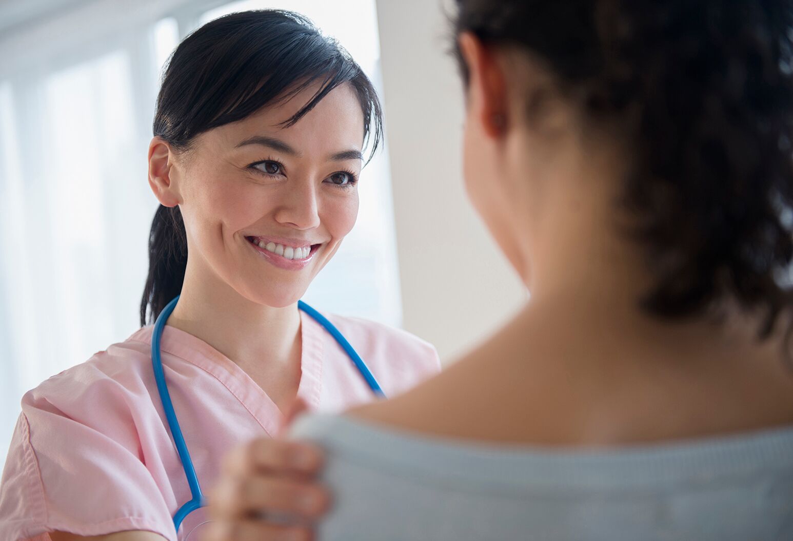 A female nurse speaks with a teenage girl