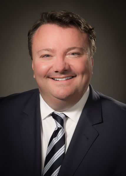 Richard Mulry wearing a black and grey striped tie