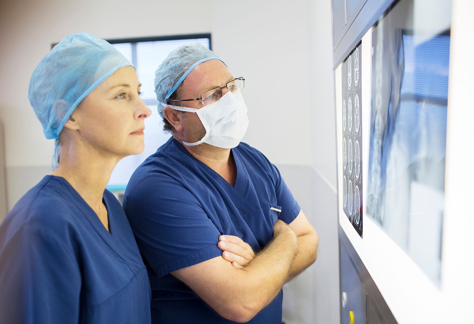 Two doctors discussing patients x-ray and MRI before surgery