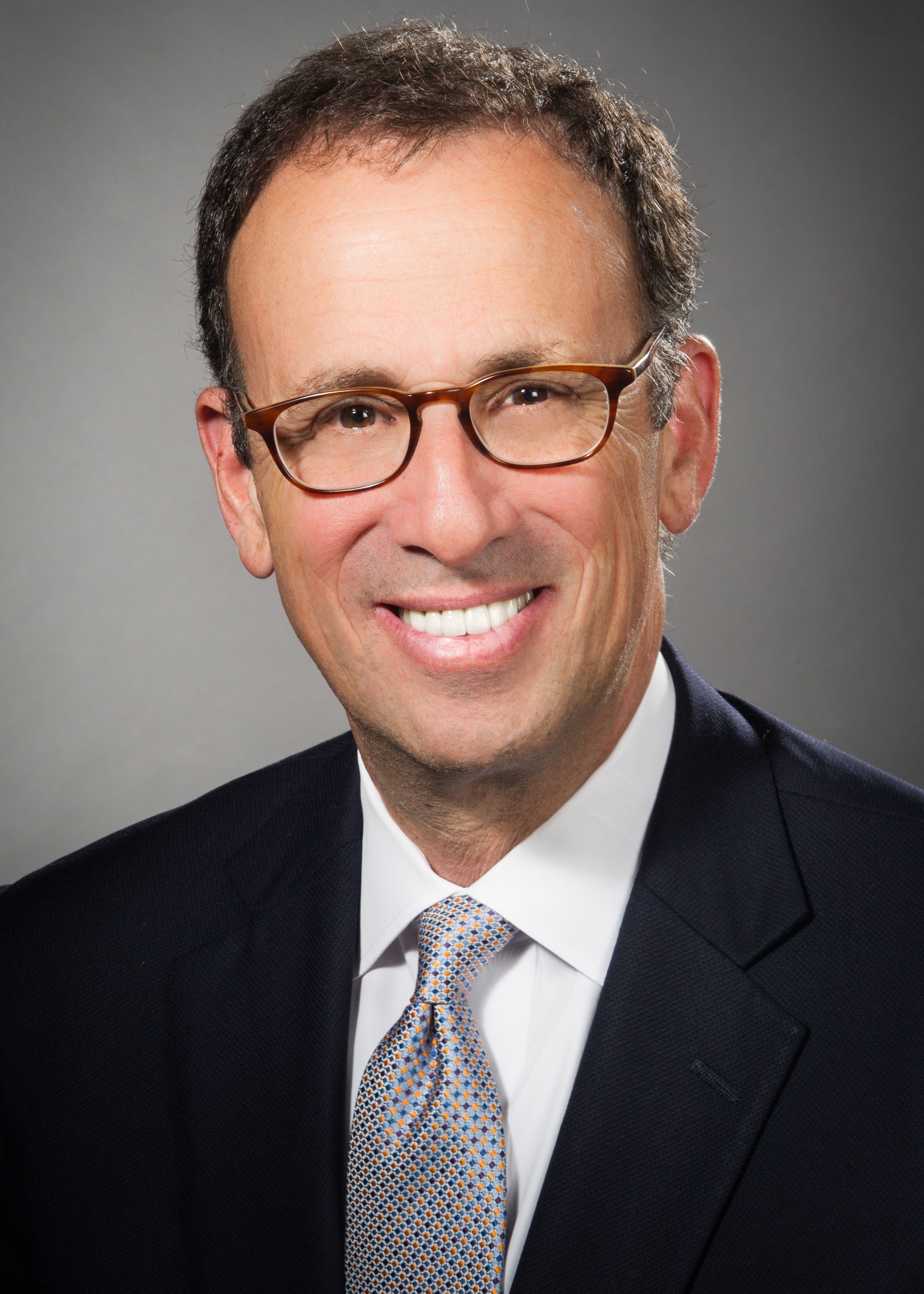 Howard Guzik, MD< wearing a black suit and silver tie