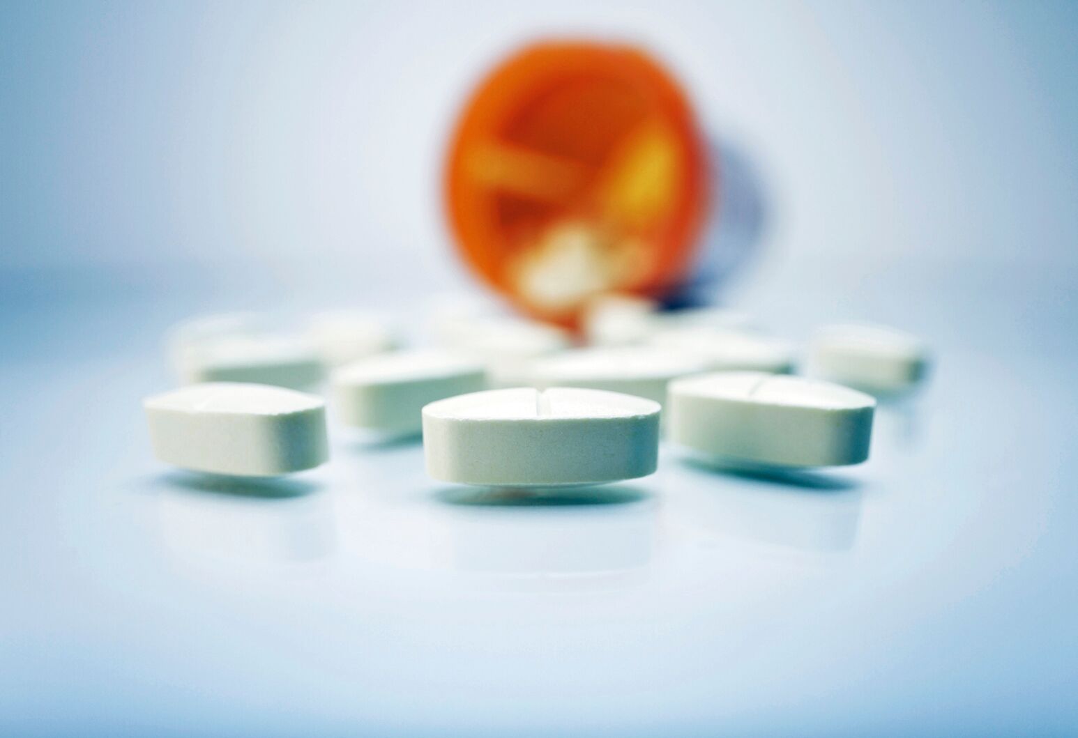 A bottle of pain pills spills over. Yili Huang, DO, says that despite tighter restrictions for opioid manufacturers proposed by the FDA, there are still questions.