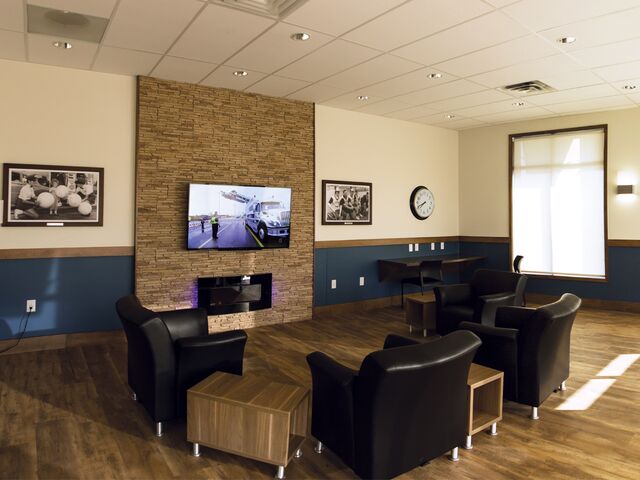 alt="black leather couches facing television in lounge" alt="black leather couches facing television in lounge"