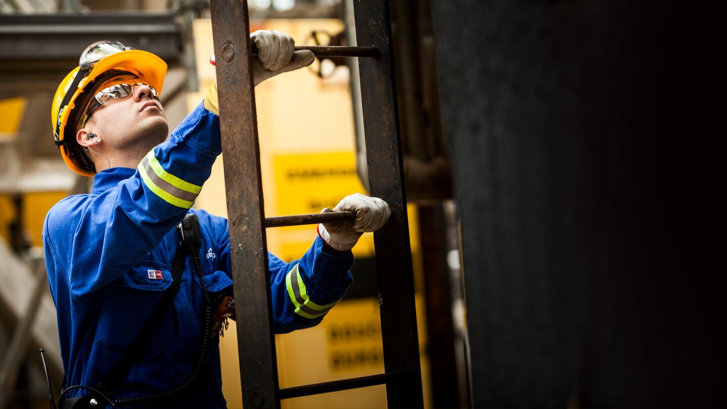 alt="refinery worker climbing ladder" alt="refinery worker climbing ladder"